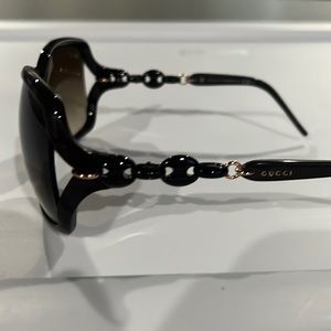 Gucci, dark brown or eggplant color sunglasses.
